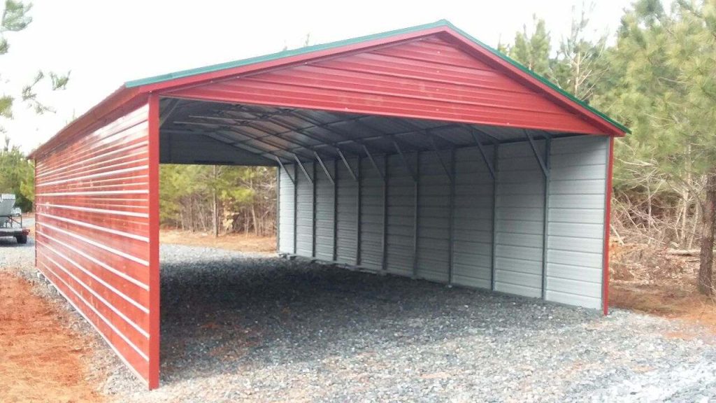 A bright red-walled carport set onto a gravel driveway.