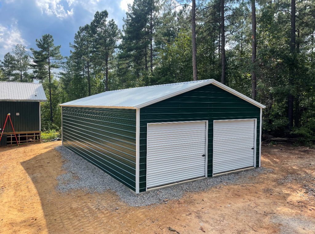 A dark green metal structure with white trim and garage doors.