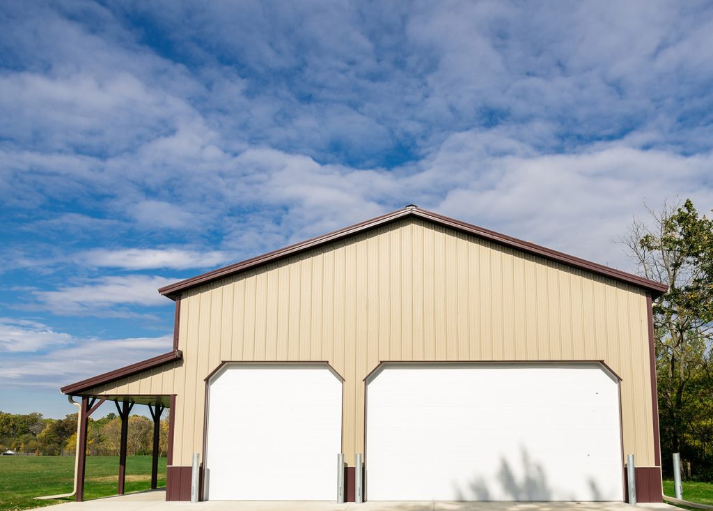 A tan building with brown trim and white garage doors