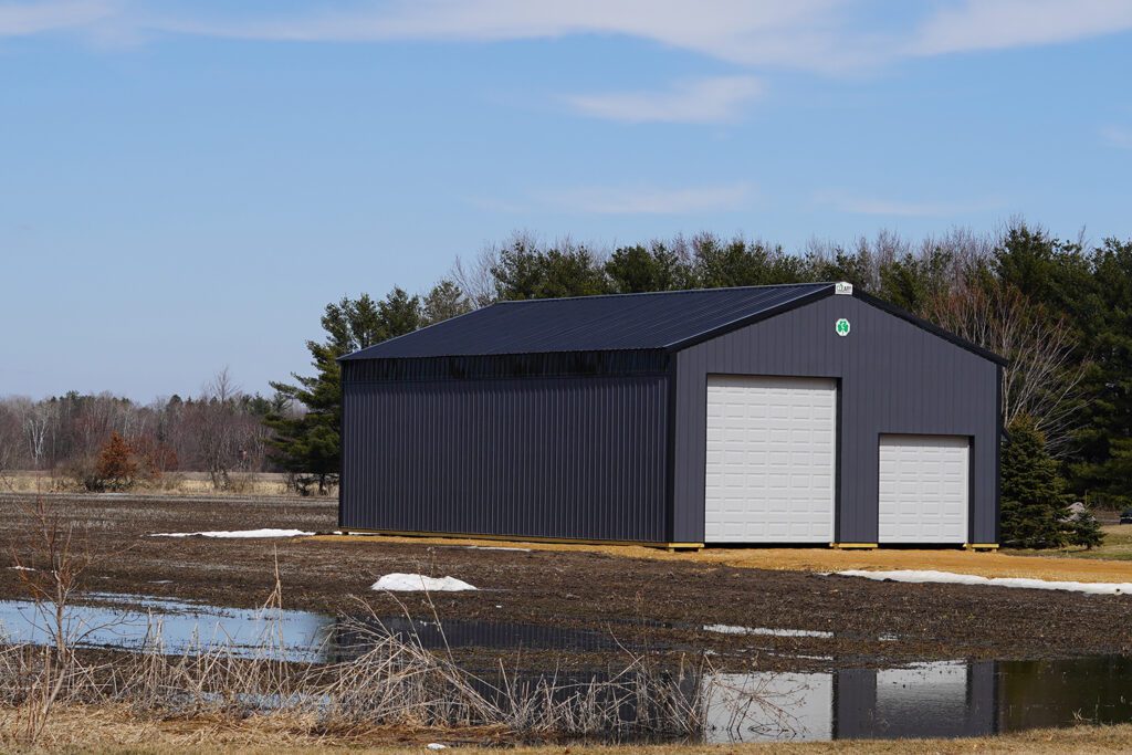 A dark metal building on a farm.